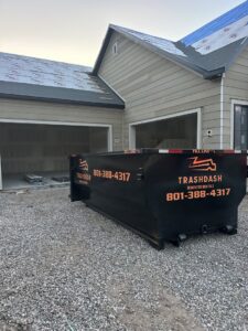 An empty TrashDash dumpster placed in front of a house under construction in West Haven, UT.