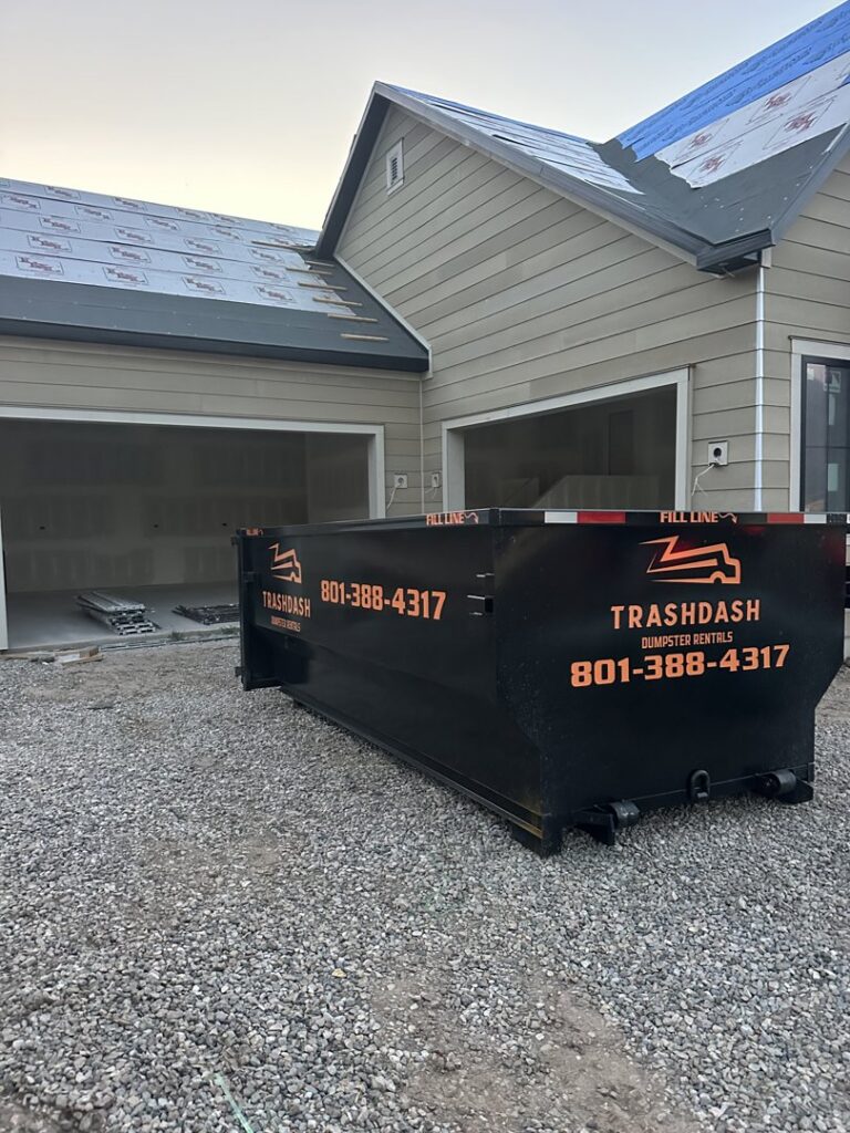 An empty TrashDash dumpster placed in front of a house under construction in West Haven, UT.