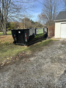 An empty Trash Hunter LLC dumpster placed on a gravel driveway in Hartville, OH, ready for junk removal.