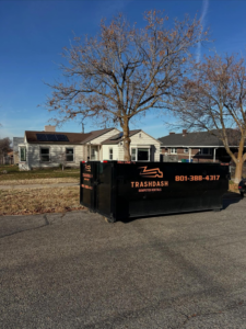 An empty TrashDash dumpster placed on a residential street, ready for junk removal in West Haven, UT.