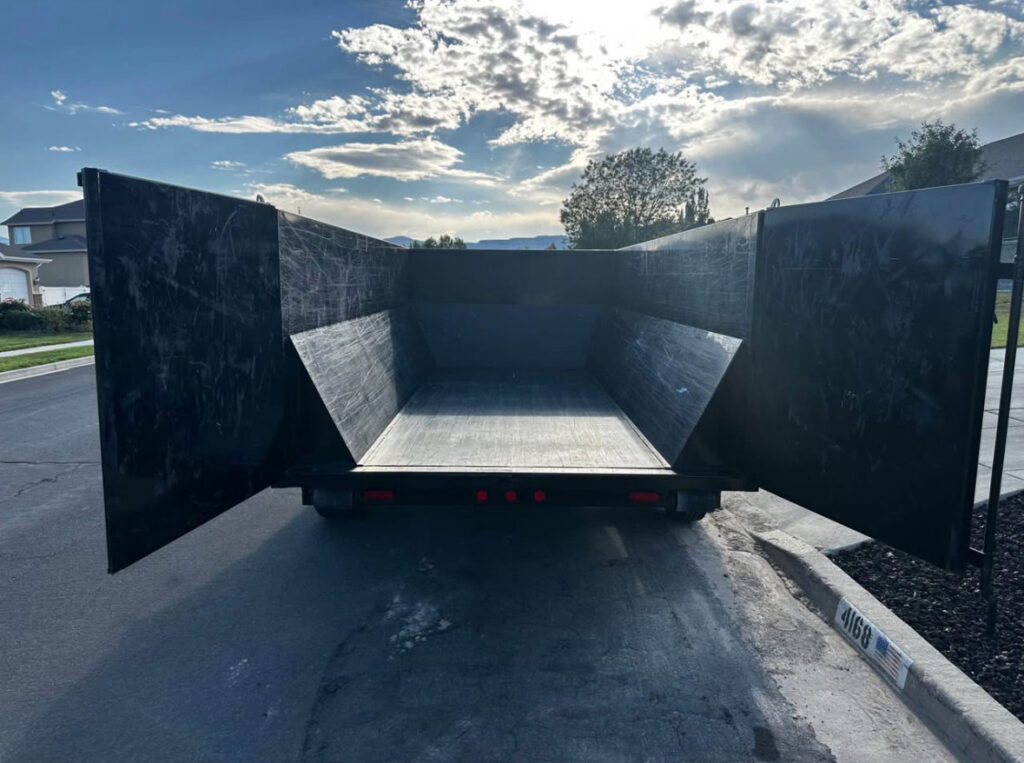 Rear view of an empty DumpsterDash-LLC dumpster in Ogden, UT, with its doors open, ready for loading.