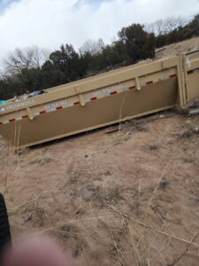 An empty dump trailer from Bin Suave LLC, available for dumpster rental services in Espanola, NM.