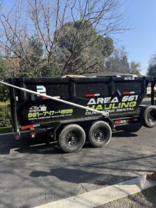 An empty dump trailer from Area 661 Hauling parked on a residential driveway, ready for junk removal in Bakersfield, CA.