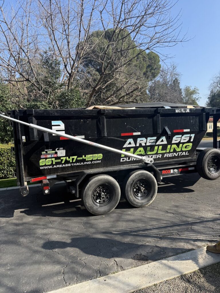 An empty dump trailer from Area 661 Hauling parked on a residential driveway, ready for junk removal in Bakersfield, CA.