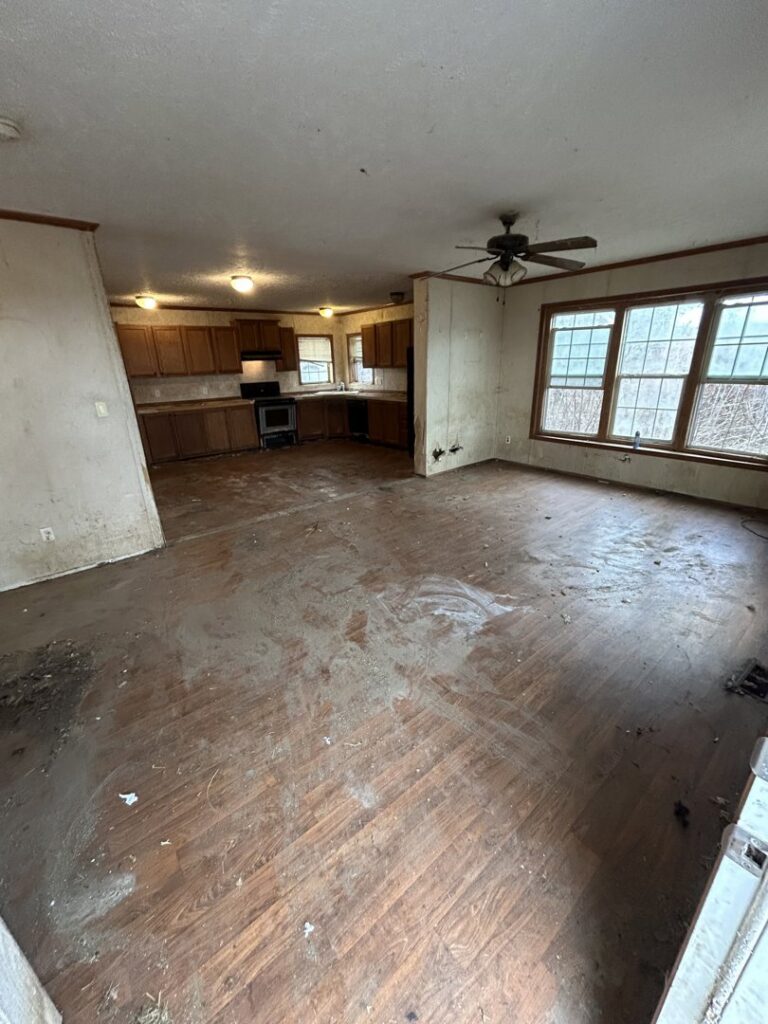 An empty living room and kitchen area after a junk removal service by Rosales Junk Removal in Des Moines, IA.