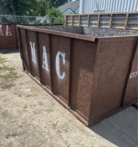 An empty MAC Containers, Inc roll-off dumpster ready for junk removal services in Omaha, NE.