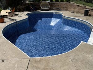 An empty swimming pool showcasing a newly installed blue liner by Heatwave Pools LLC in Flint, MI.