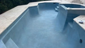 An empty swimming pool showcasing new plaster and tiling work by Austin Pool Plastering in Austin, TX.