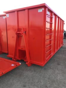 An empty red roll-off dumpster, ready for use by ADE Hauling in Tacoma, WA