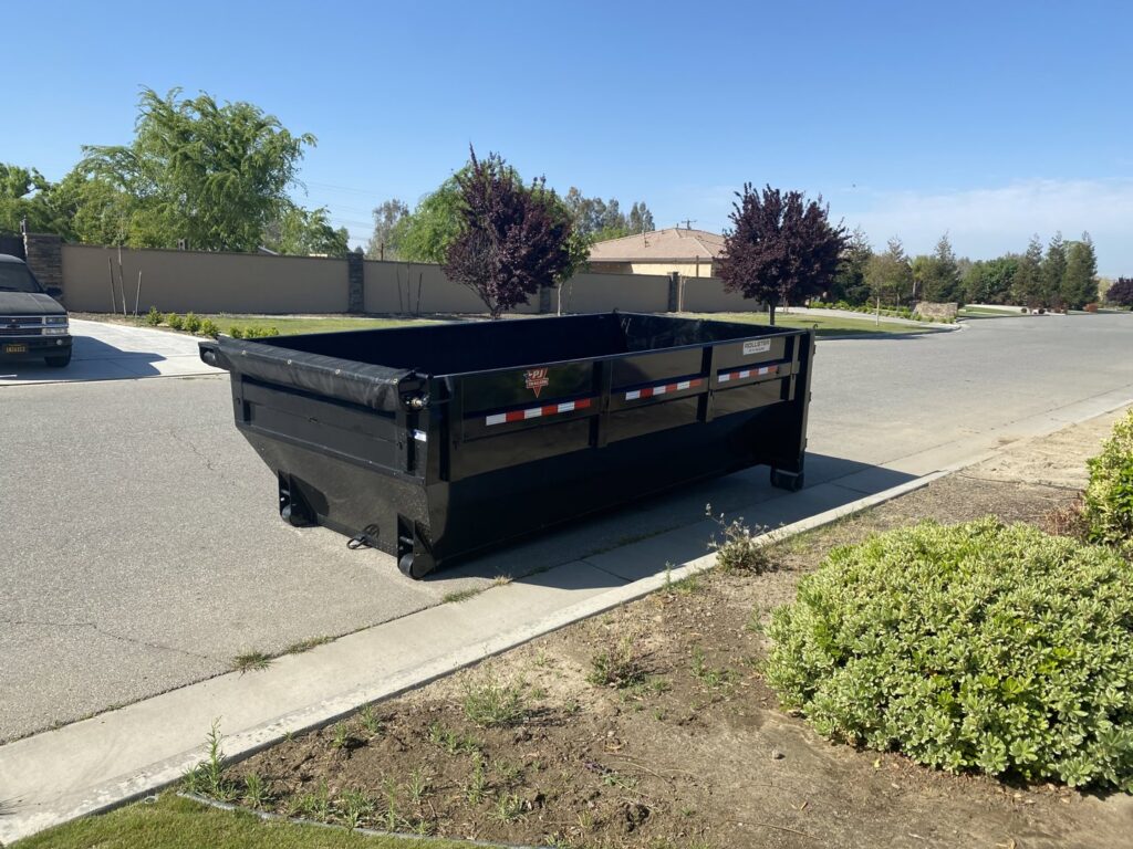 An empty roll-off dumpster placed on a residential street or driveway by Bakersfield Roll-Off Service in Bakersfield, CA.