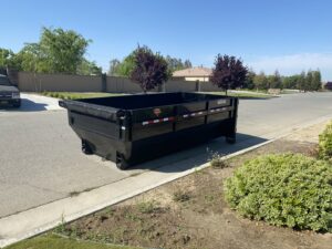 An empty roll-off dumpster placed on a residential street or driveway by Bakersfield Roll-Off Service in Bakersfield, CA.