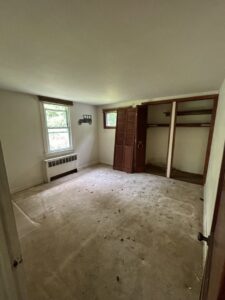An empty room with dirty carpet and open closet, typical of a cleanout by JDog Junk Removal & Hauling Capital Region NY in Schenectady, NY.