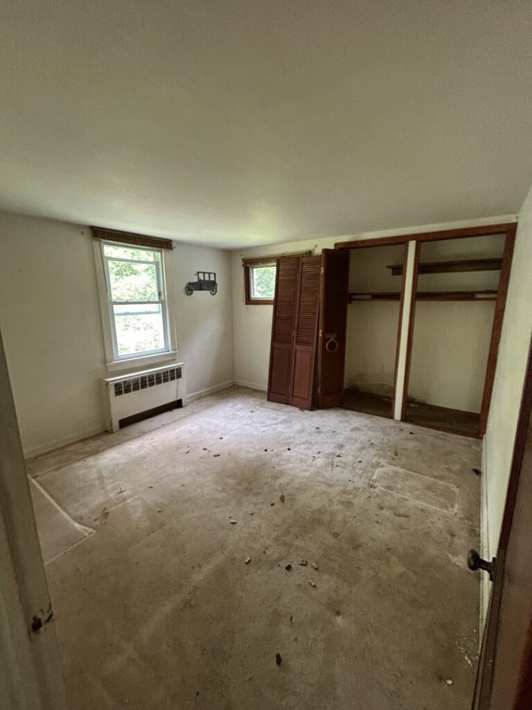 An empty room with dirty carpet and open closet, typical of a cleanout by JDog Junk Removal & Hauling Capital Region NY in Schenectady, NY.