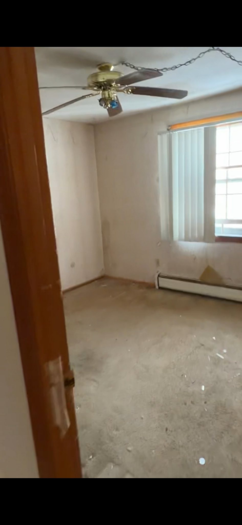 An empty room with old carpet, showing the successful completion of a cleanout service by DJ's Junk Removal in Laconia, NH.