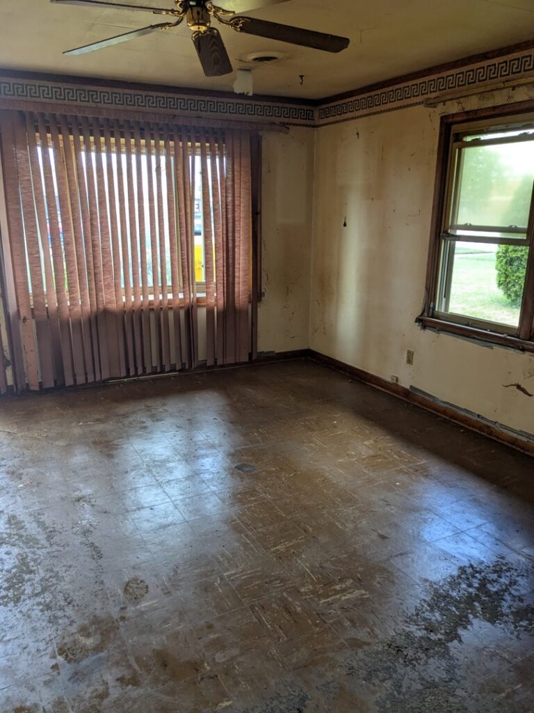 An empty room with dirty walls and floor, indicating a property cleanout service by Merica JunkBoss LLC in Hammond, IN.
