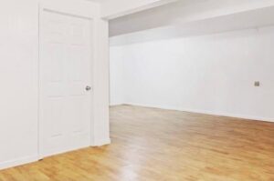An empty room showcasing new hardwood flooring and white walls by Creative Touch Renovations LLC in Harrisburg, PA.