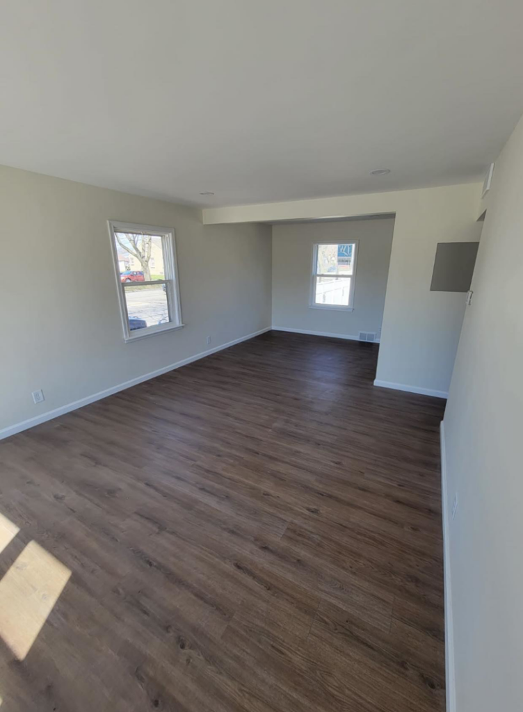 An empty room showcasing new hardwood-style flooring and freshly painted walls by J&A Contractor LLC in Milwaukee, WI.