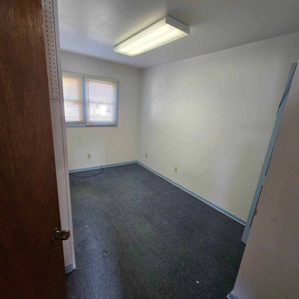 An empty small room with white walls and dark carpet, suitable for painting, flooring, or light fixture installation by 1st State's Finest LLC in Middletown, DE.