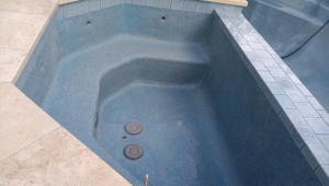 An empty spa with a fresh plaster finish and blue tile coping, completed by Austin Pool Plastering in Austin, TX.