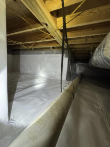 An encapsulated crawlspace showing pipes and a white vapor barrier installed by Humidi-Seal Crawlspace Solutions in Charleston, SC.