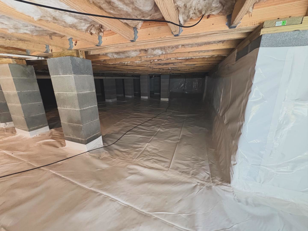 A newly encapsulated crawlspace with a clean vapor barrier and support piers installed by Crawlspace Medic of Knoxville, TN