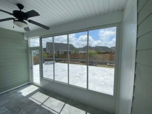 An enclosed patio featuring large windows and a view of a paved backyard, built by NRG Industries in Tallahassee, FL.