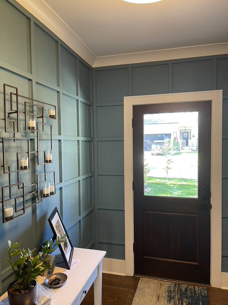 A beautifully finished entryway with teal board and batten wainscoting by CM Home Contracting LLC in Charleston, SC.