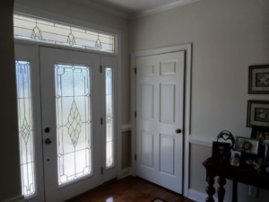 An entryway featuring a decorative front door and a standard interior door, installed by Quiros Remodeling in Greenville, SC.
