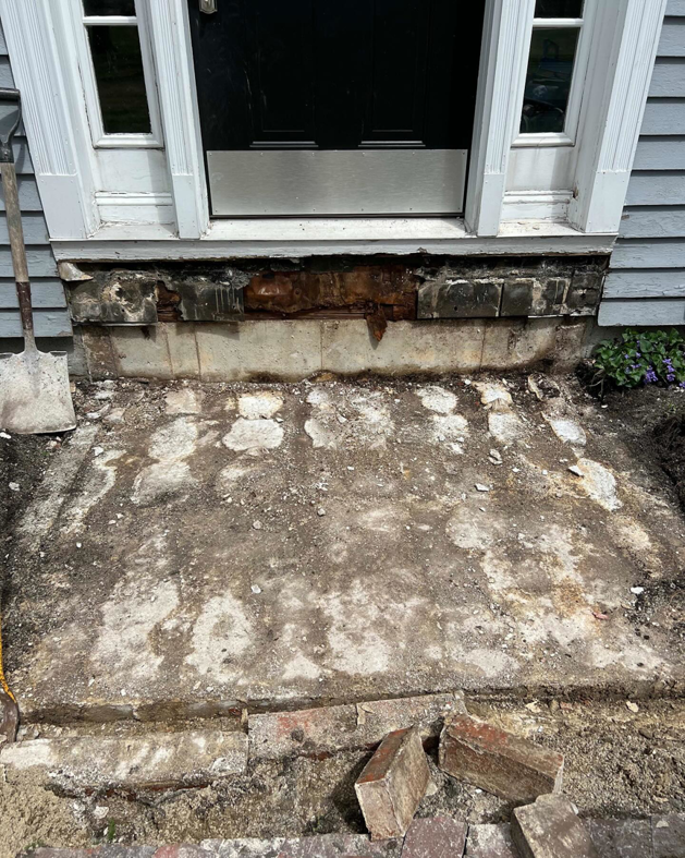 Entryway demolition in progress, showing exposed foundation during a renovation by Blackcap Handyman in Portland, ME.