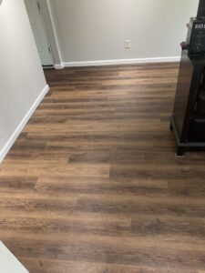 An entryway featuring newly installed wood laminate flooring and fresh paint, a handyman service from Newhouse Construction St Louis in St. Louis, MO.