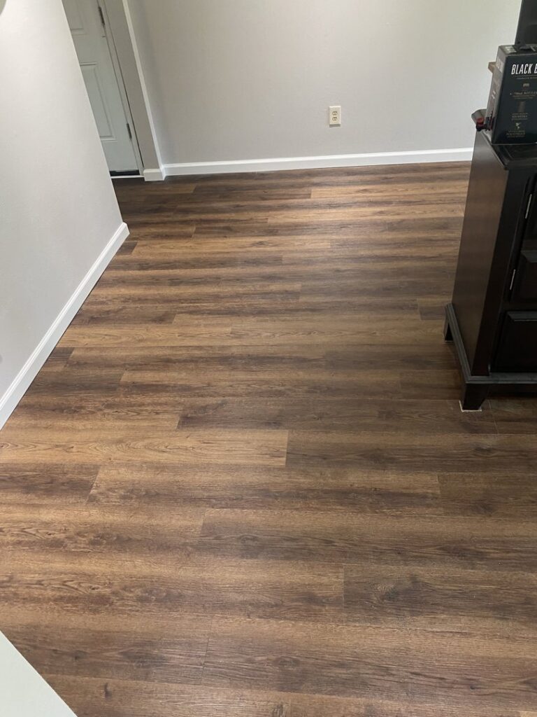 An entryway featuring newly installed wood laminate flooring and fresh paint, a handyman service from Newhouse Construction St Louis in St. Louis, MO.