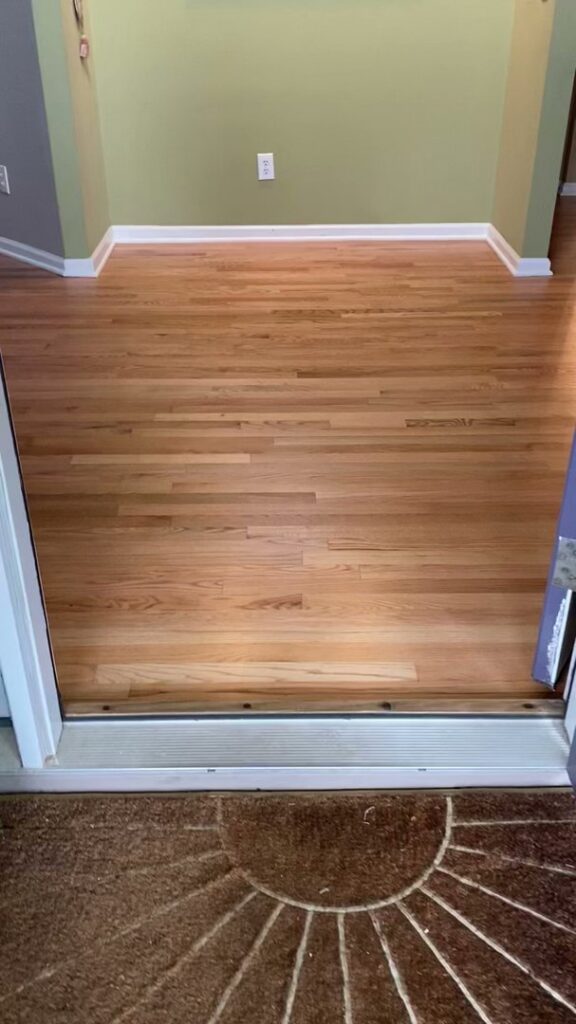 Refinished hardwood flooring in an entryway by Santizo Flooring & Painting in Raleigh, NC.