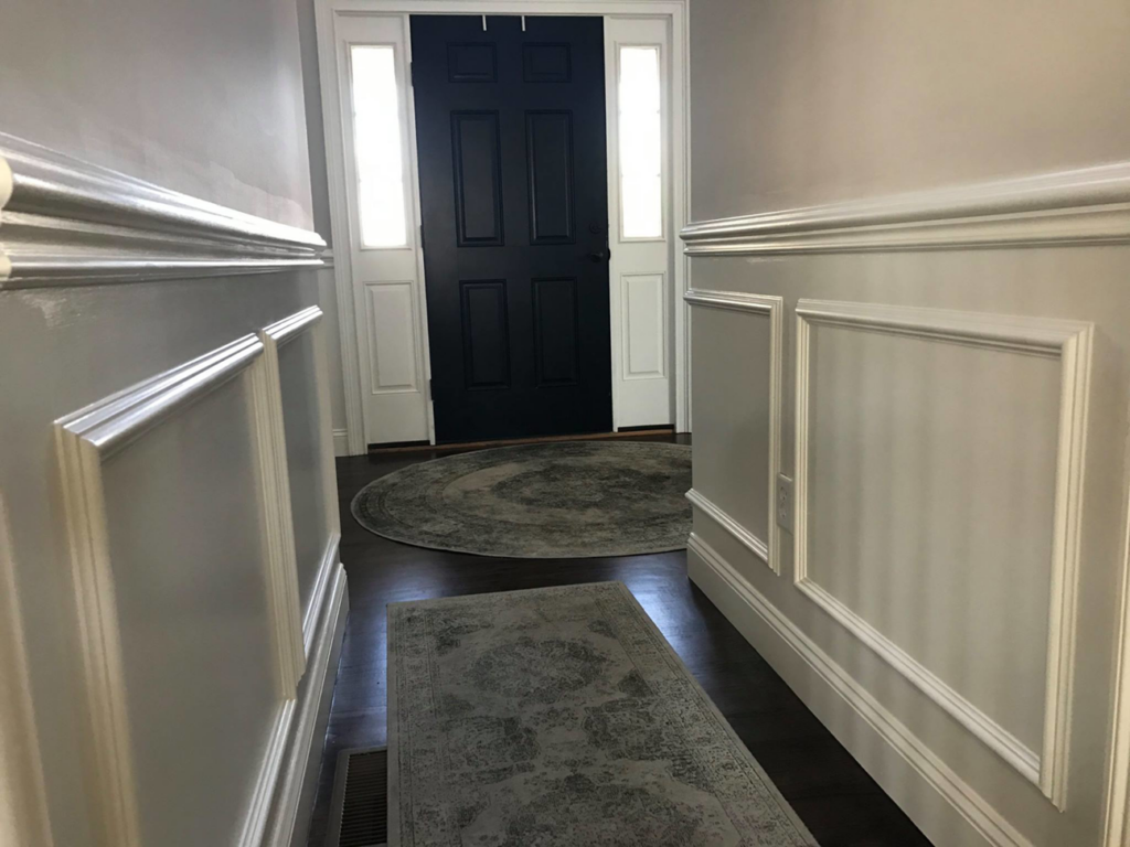 A welcoming entryway featuring custom wainscoting and a newly installed front door by O'Shaughnessy Construction in Salem, NH.