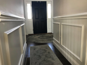 A welcoming entryway featuring custom wainscoting and a newly installed front door by O'Shaughnessy Construction in Salem, NH.