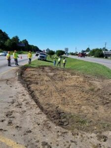 A site with disturbed earth and workers, indicating an ongoing environmental cleanup project by Environmental & Hazmat Services in Ashford, AL.