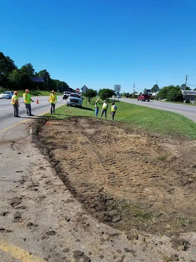 A site with disturbed earth and workers, indicating an ongoing environmental cleanup project by Environmental & Hazmat Services in Ashford, AL.