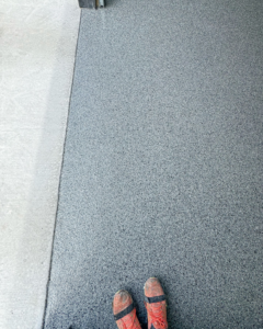 A close-up comparison of a new epoxy floor coating next to original concrete by Apex Custom Coatings in Middleton, WI