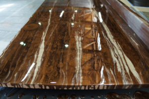 A close-up of a wooden surface with a glossy, swirled epoxy resin coating applied by Forte Painting Company in Boulder, CO.