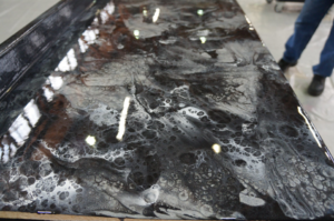 A glossy, swirled black, white, and grey epoxy resin floor coating applied by Forte Painting Company in Boulder, CO.