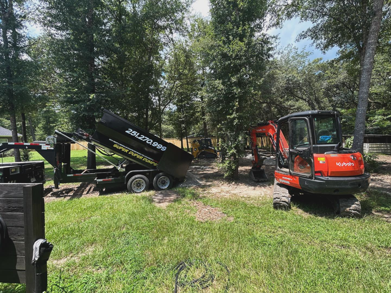 A Super Duper Dumpsters roll-off trailer positioned next to an excavator for debris removal in Mobile, AL.