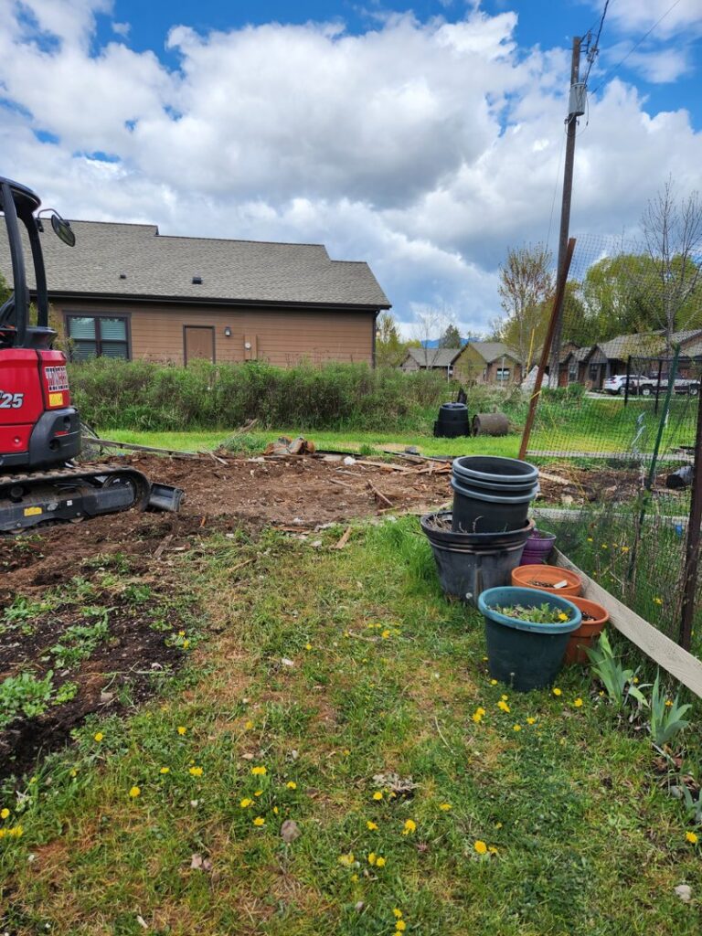 An excavator clearing debris from a site, indicating heavy-duty junk removal and site preparation by Junk Hunks 406 in Missoula, MT.