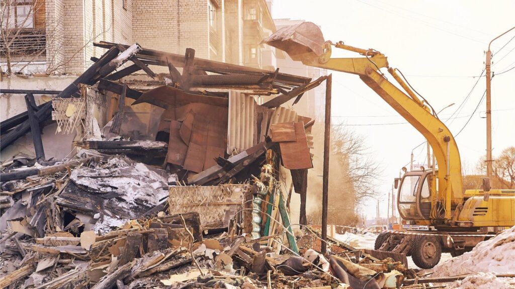 An excavator demolishing a building, showing demolition services by Insta Junk Removal & Demolition LLC in Salisbury, MD