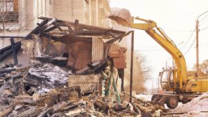 An excavator demolishing a building, showing demolition services by Insta Junk Removal & Demolition LLC in Salisbury, MD