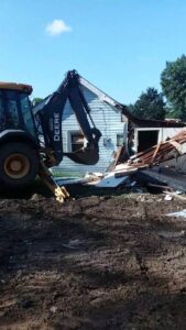 An excavator performing demolition work on a house by B & L Builders in Jonesborough, TN