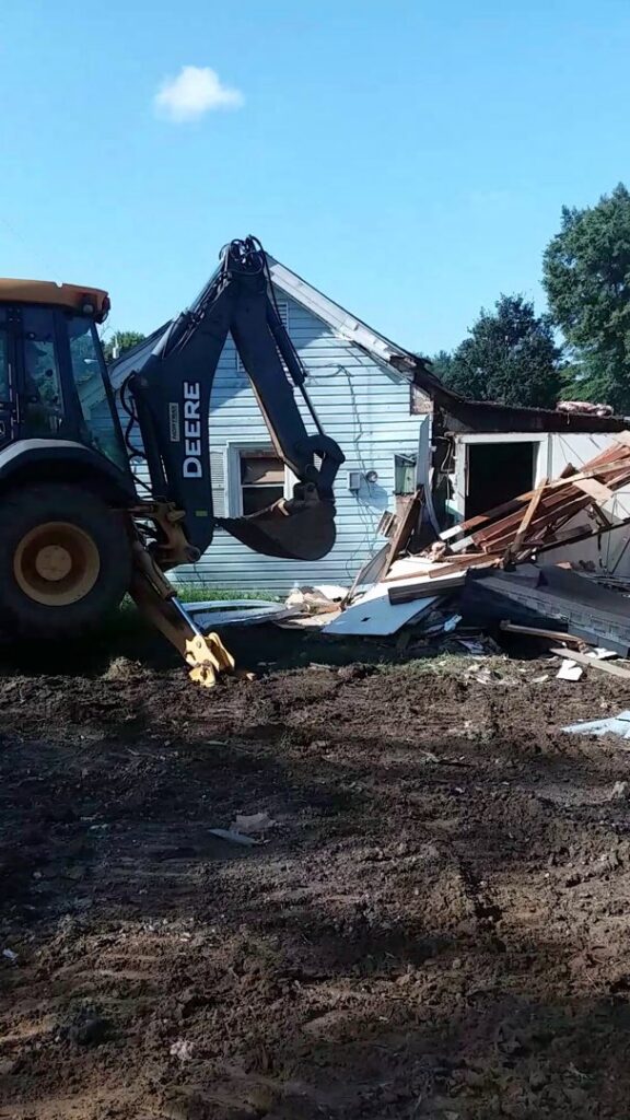 An excavator performing demolition work on a house by B & L Builders in Jonesborough, TN