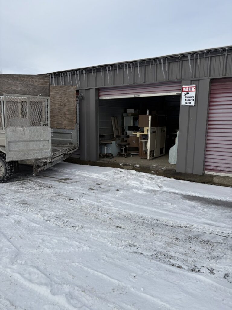 An excavator demolishing a trailer or mobile home, demonstrating demolition and junk removal by Tiny's Trash & Hauling Service L.L.C in Williamstown, VT