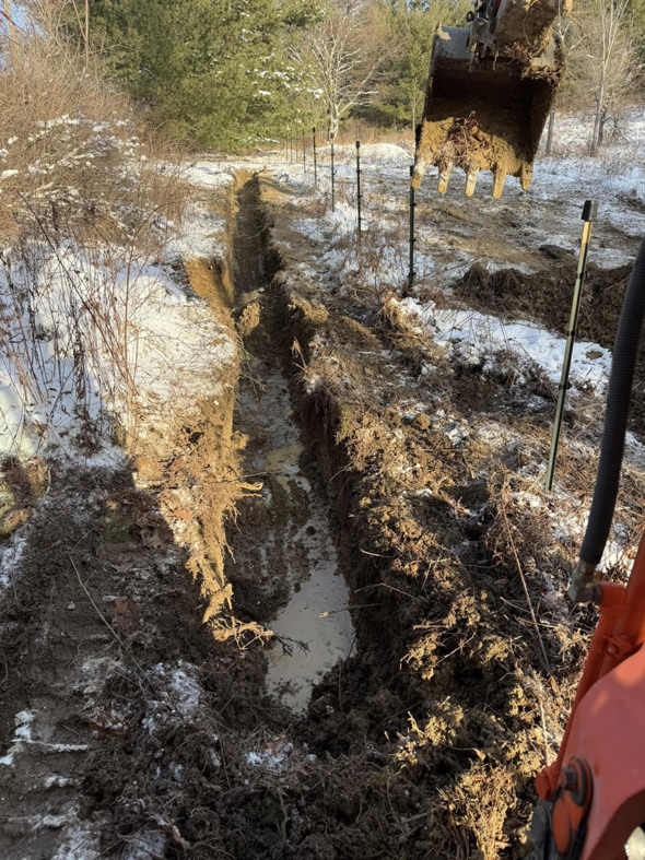 An excavator digging a trench for site excavation by Naz General Contracting LLC in Schenectady, NY.