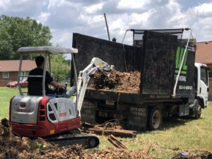 An excavator loading debris into a G.I.HAUL ATLANTA junk removal truck during a job in Atlanta, GA.