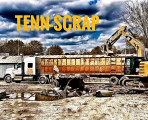 An excavator loading scrap metal into a Tenn-Scrap branded semi-trailer for transport in Jackson, TN.