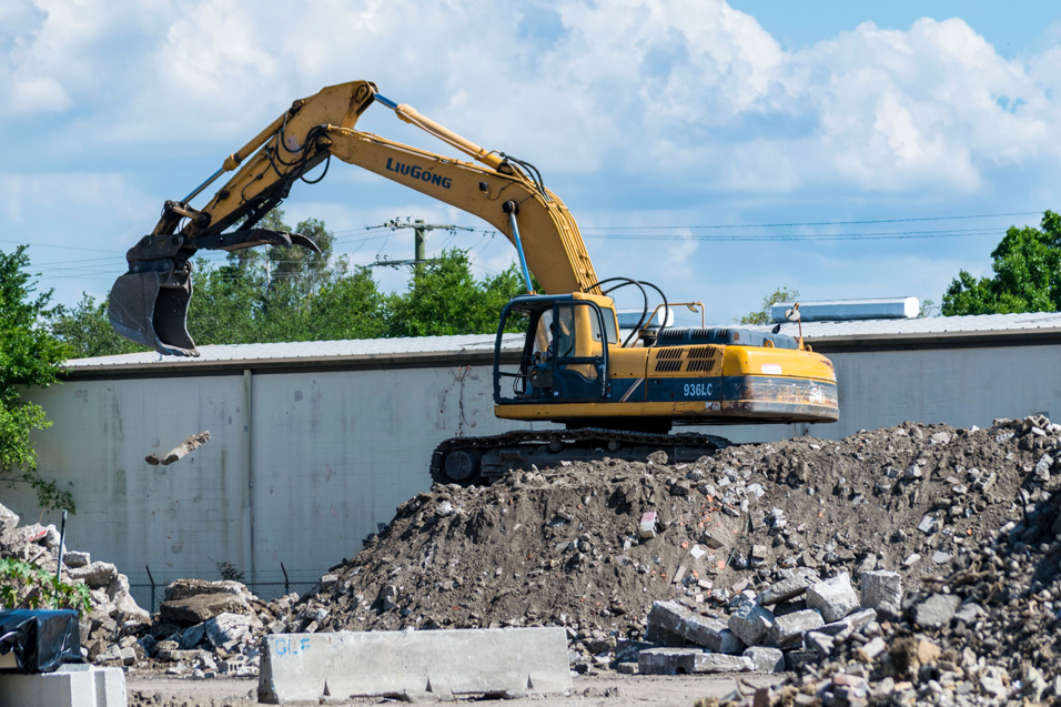 An excavator moving construction and demolition debris at Global Recycling of Tampa Bay in Tampa, FL.
